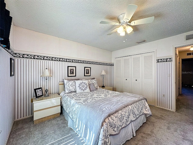 bedroom with carpet, a textured ceiling, visible vents, and a closet