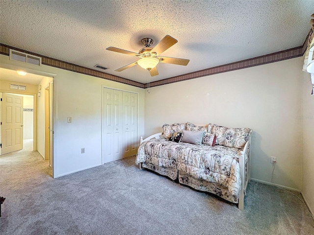 bedroom featuring carpet floors, visible vents, crown molding, and a textured ceiling