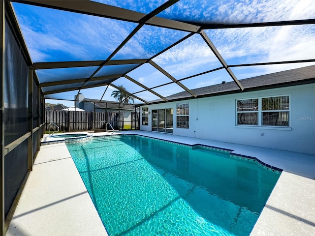 view of swimming pool with glass enclosure, a patio area, and a pool with connected hot tub