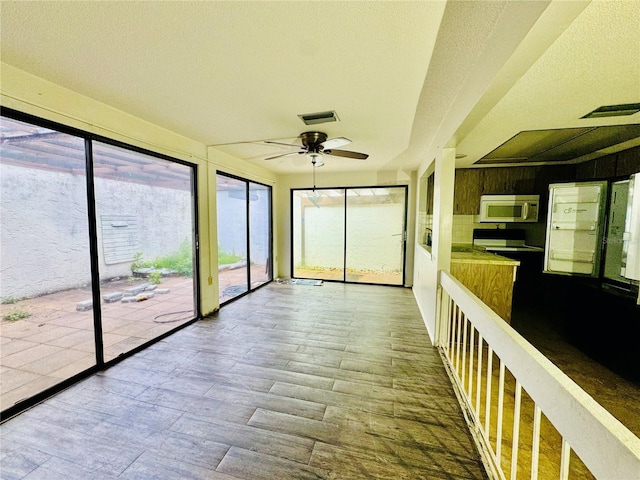 unfurnished sunroom with ceiling fan and visible vents