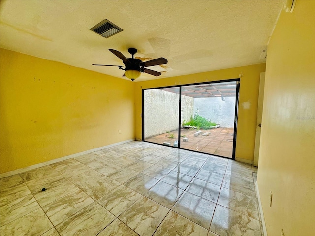 unfurnished room featuring a textured ceiling, a ceiling fan, visible vents, and baseboards