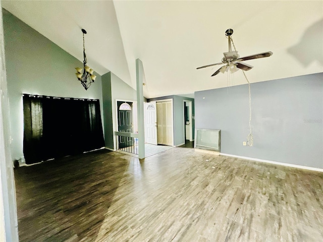 unfurnished living room with lofted ceiling, baseboards, wood finished floors, and ceiling fan with notable chandelier