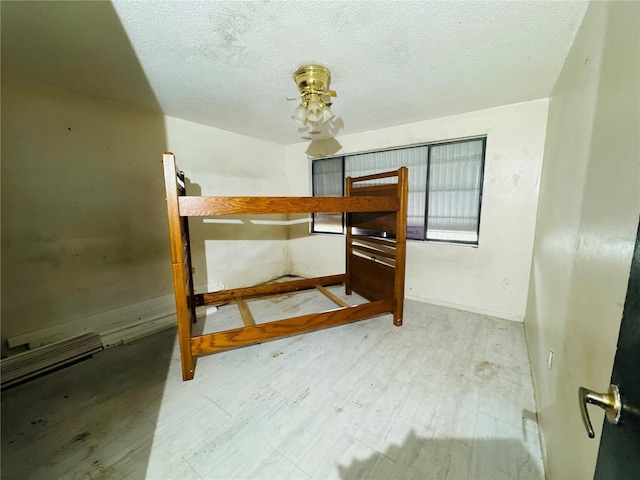 unfurnished bedroom featuring a textured ceiling and light wood finished floors