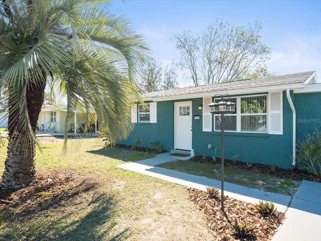 view of front facade featuring a front yard and stucco siding