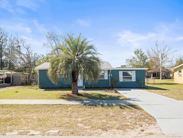 view of front of property featuring fence, a front lawn, and stucco siding