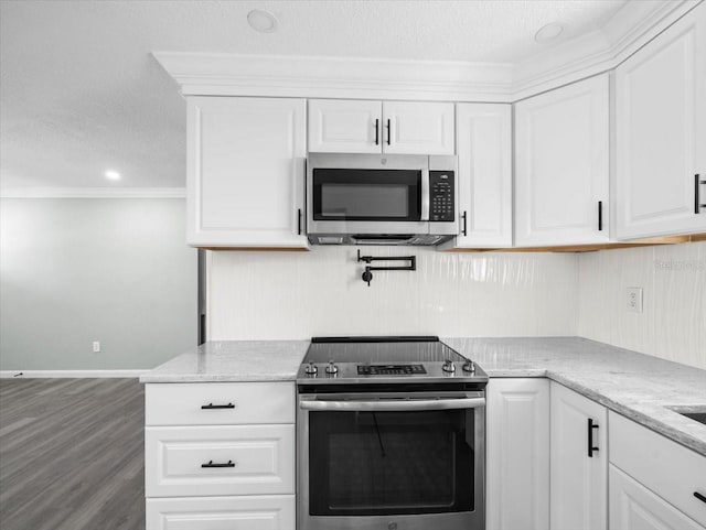 kitchen with a textured ceiling, appliances with stainless steel finishes, and white cabinets