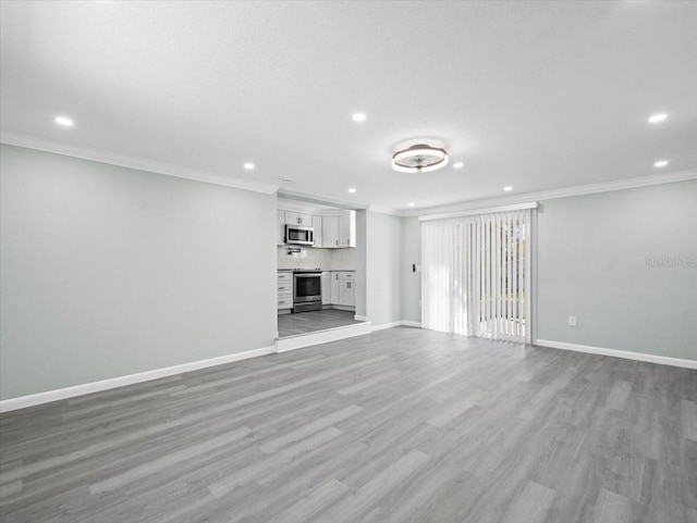 unfurnished living room with baseboards, ornamental molding, recessed lighting, and light wood-style floors