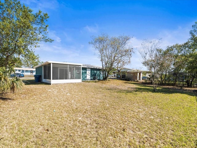 back of house featuring a sunroom and a yard