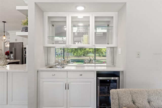 bar featuring beverage cooler, decorative light fixtures, a sink, decorative backsplash, and high end refrigerator