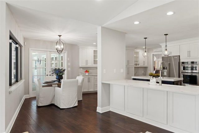 kitchen featuring white cabinetry, glass insert cabinets, dark wood-style flooring, and appliances with stainless steel finishes