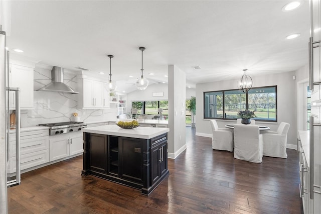 kitchen featuring tasteful backsplash, stainless steel gas cooktop, light countertops, white cabinetry, and wall chimney exhaust hood