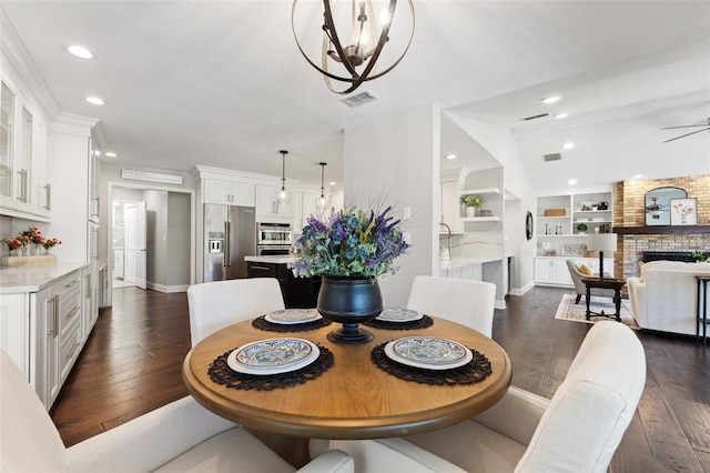 dining room with visible vents, a brick fireplace, recessed lighting, and dark wood-style flooring