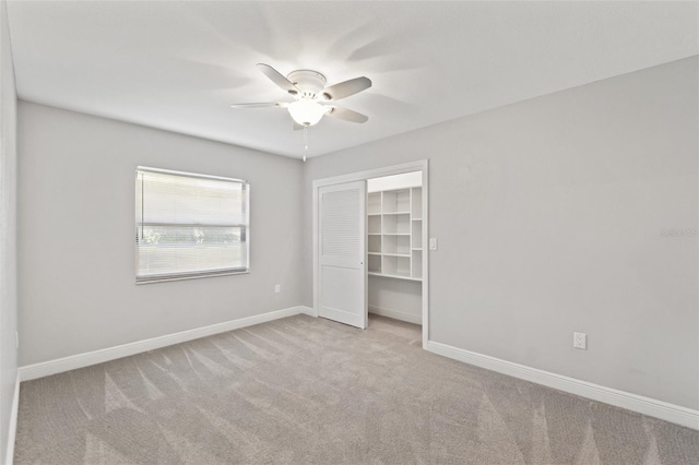 unfurnished bedroom with baseboards, carpet floors, a closet, and ceiling fan