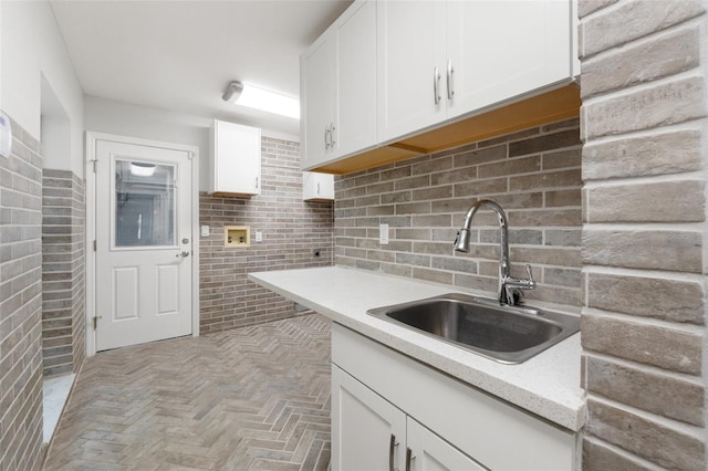 kitchen with white cabinetry, tasteful backsplash, and a sink