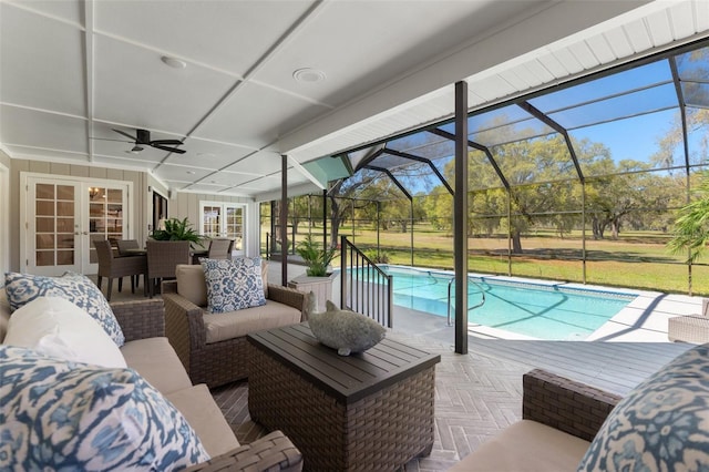 outdoor pool featuring glass enclosure, french doors, an outdoor hangout area, a patio area, and a ceiling fan