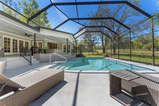 outdoor pool with glass enclosure, a patio, a ceiling fan, and french doors