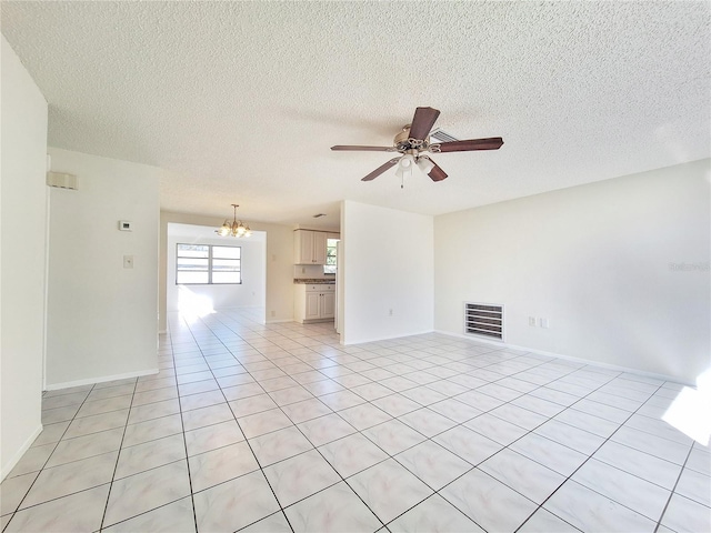 spare room featuring light tile patterned floors, baseboards, visible vents, a textured ceiling, and ceiling fan with notable chandelier