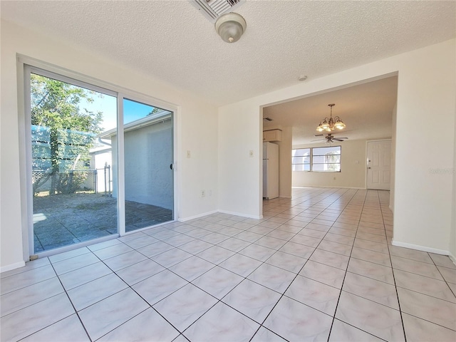 spare room with baseboards, visible vents, a textured ceiling, a chandelier, and light tile patterned flooring