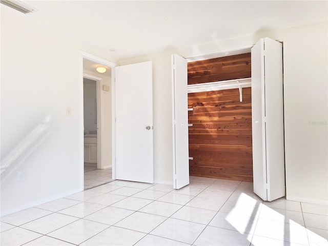 interior space featuring visible vents, wood walls, and light tile patterned flooring