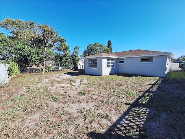 back of property featuring a yard, a fenced backyard, and stucco siding