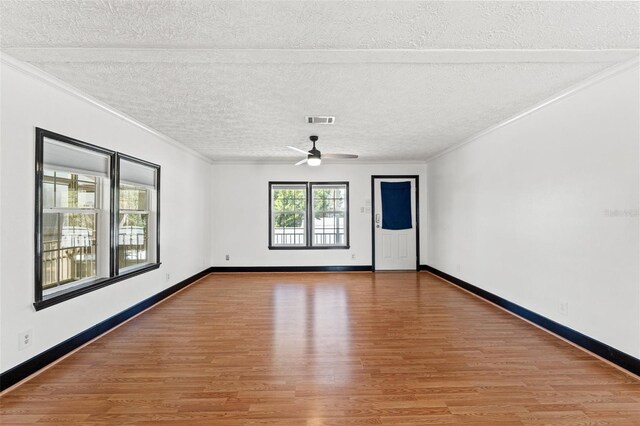 unfurnished room featuring a ceiling fan, crown molding, light wood-style floors, and baseboards