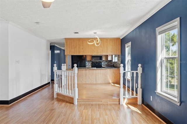 kitchen with backsplash, black appliances, light wood-style floors, and ornamental molding