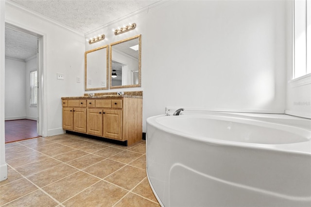 bathroom featuring crown molding, a garden tub, tile patterned floors, a textured ceiling, and vanity