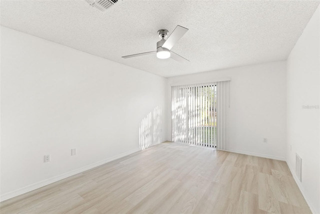 spare room featuring a textured ceiling, ceiling fan, light wood-type flooring, and visible vents