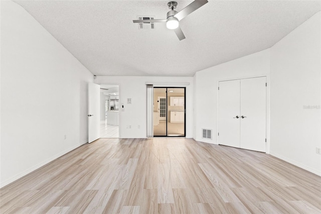 unfurnished bedroom with light wood-style flooring, visible vents, ceiling fan, and a textured ceiling