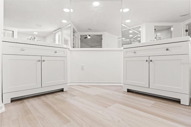 full bath with two vanities, walk in shower, and wood finished floors