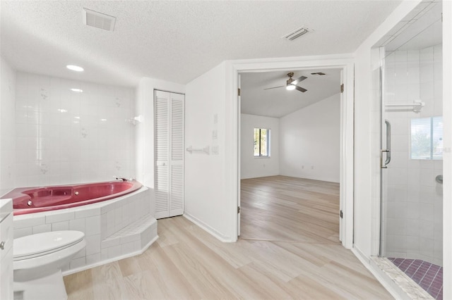 bathroom featuring a textured ceiling, wood finished floors, visible vents, a closet, and a bath