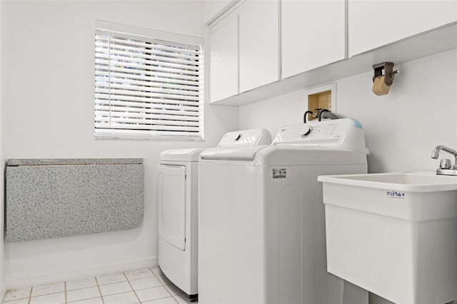 clothes washing area with light tile patterned flooring, cabinet space, a sink, and separate washer and dryer