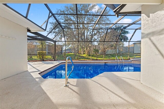 outdoor pool with glass enclosure and a patio area