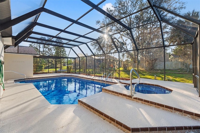 outdoor pool featuring an in ground hot tub, a patio area, and glass enclosure