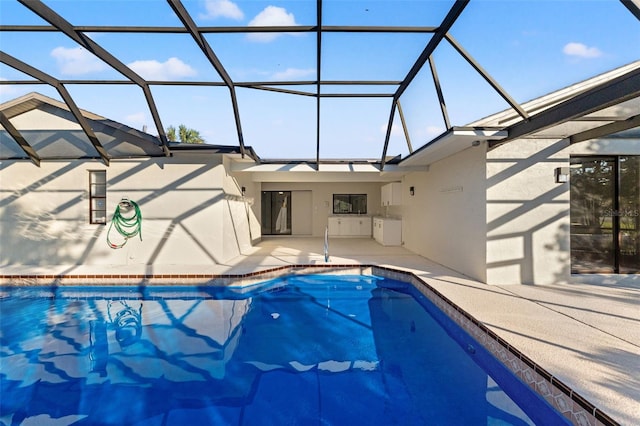 pool featuring glass enclosure and a patio area