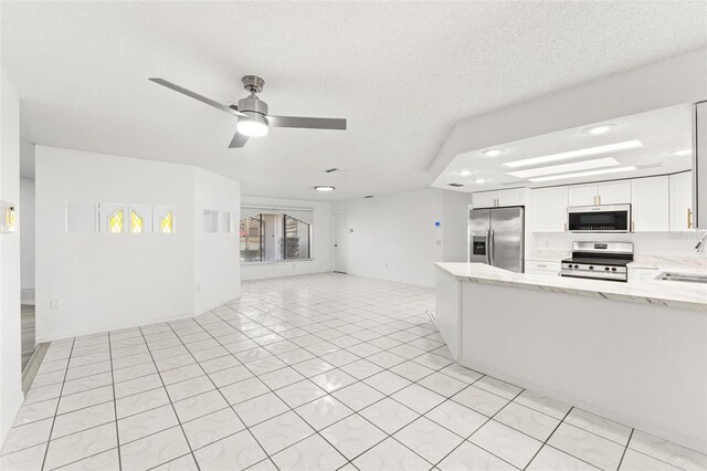 1011 Altoona Ave, Spring Hill, FL 34609 - kitchen with stainless steel appliances, open floor plan, light stone counters, white cabinetry, and recessed lighting