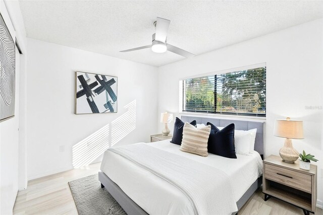 1011 Altoona Ave, Spring Hill, FL 34609 - bedroom with light wood-style floors, ceiling fan, and a textured ceiling