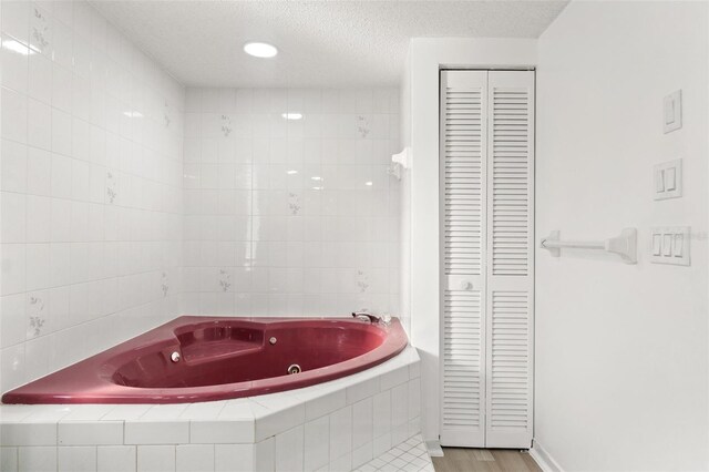 1011 Altoona Ave, Spring Hill, FL 34609 - full bathroom featuring a closet, a tub with jets, and a textured ceiling