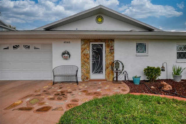 view of front of property featuring a garage, stone siding, and stucco siding