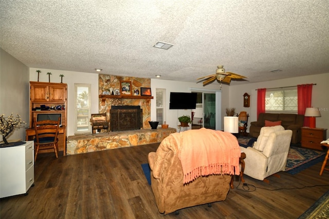 living room featuring a textured ceiling, a fireplace, and wood finished floors