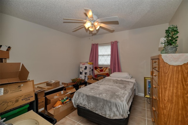 bedroom with ceiling fan, a textured ceiling, and tile patterned floors