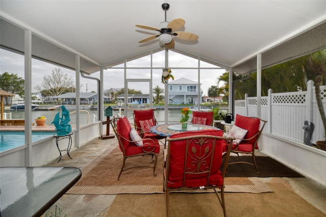 sunroom / solarium featuring a ceiling fan, lofted ceiling, and a healthy amount of sunlight