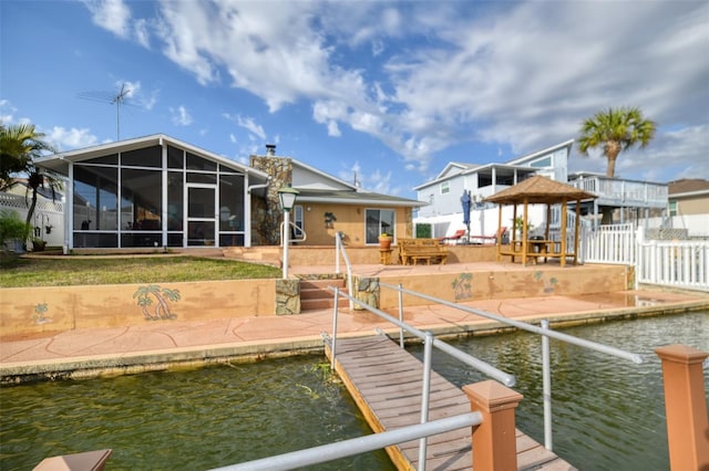 dock area with a water view, a patio, a gazebo, and fence