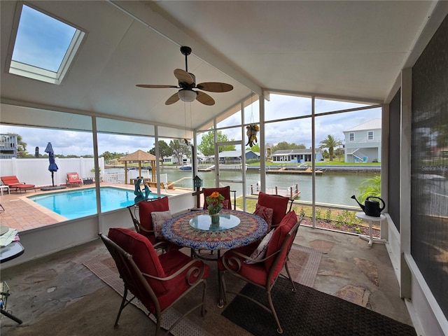 sunroom / solarium featuring a water view, ceiling fan, and a wealth of natural light
