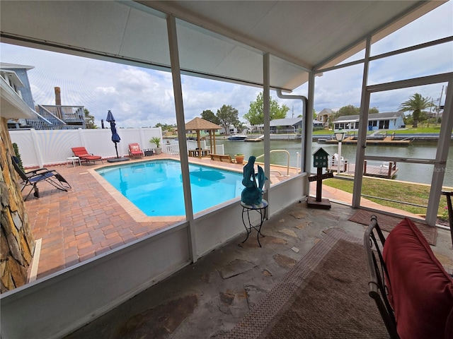 view of pool featuring a patio, a water view, and fence