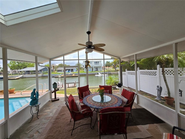 sunroom with a water view and ceiling fan