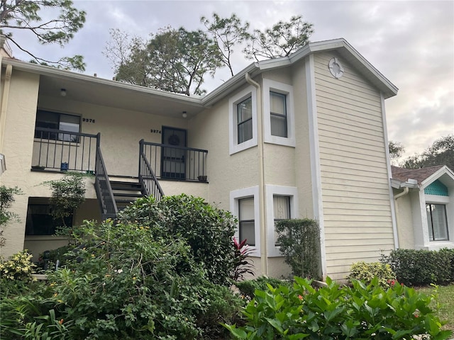 exterior space with stairs and stucco siding