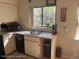 kitchen featuring black appliances, white cabinetry, light countertops, and a sink