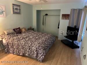 bedroom with ceiling fan, a closet, and wood finished floors