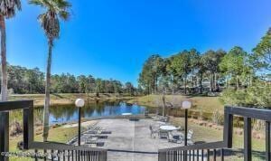 view of dock with a water view and a patio